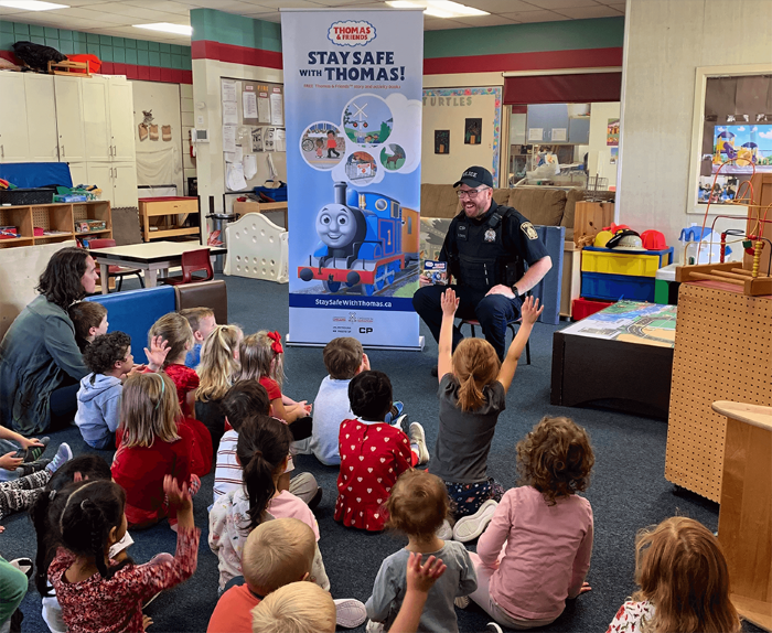 an officer teaching rail safety to children